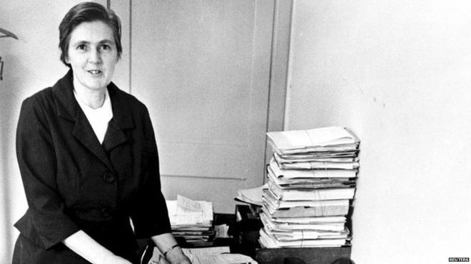 Francis Oldham pictured at her desk with piles of documents