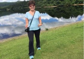 Beneficiary Helen Shore taking a walk in the countryside by a lake