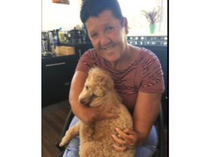 Thalidomide Trust volunteer Jean cuddling her per dog