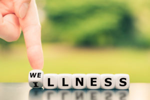 letter blocks showing illness turning into wellness