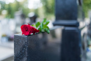 red rose on tombstone to symbolise grief