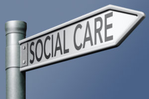 signpost with the words social care