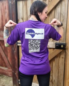 Picture of the back of a purple tshirt that has the Disability Rights UK logo on