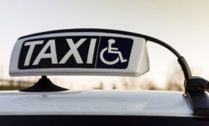 Roof of a taxi showing a taxi sign including a wheelchair symbol indicating it is an accessible vehicle