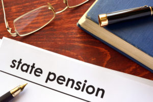 Paper with title state pension on a table, with pen and glasses